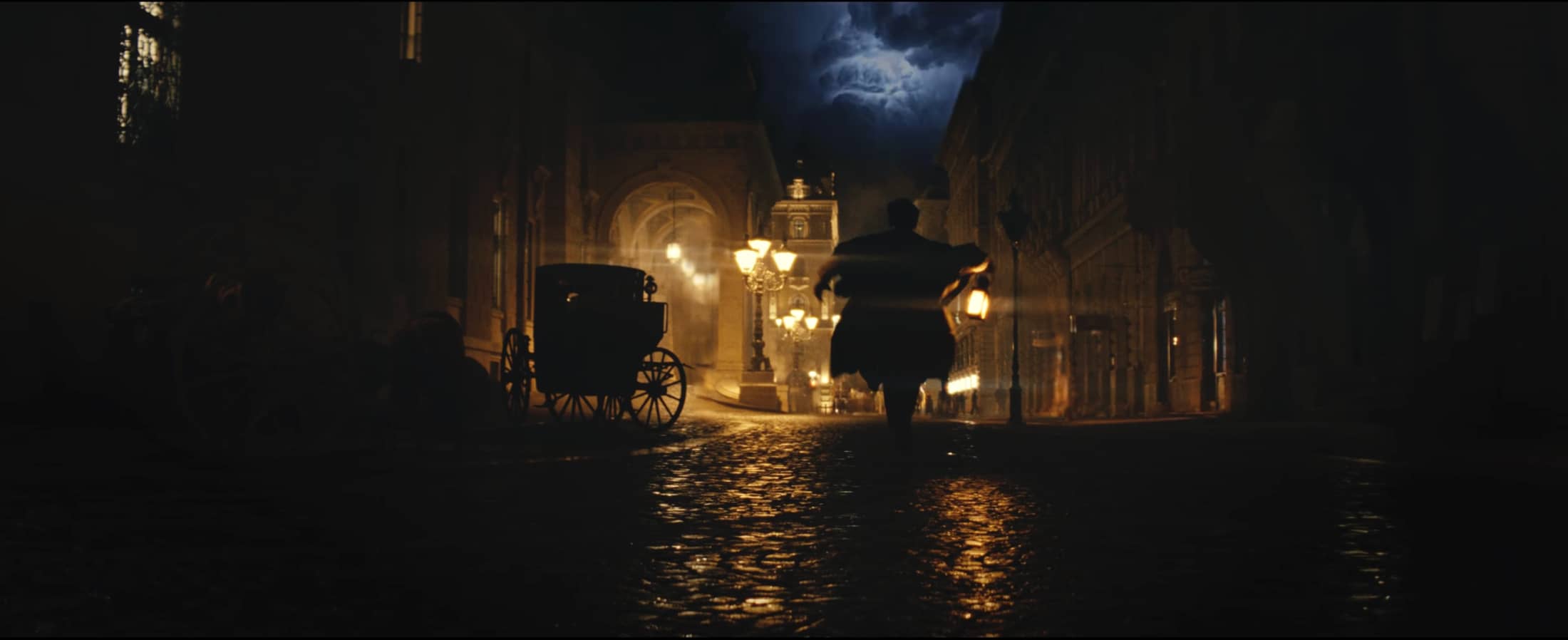 A solitary figure on a golden, lamplit street in Henry Roberts’ The Dawn of a Legacy